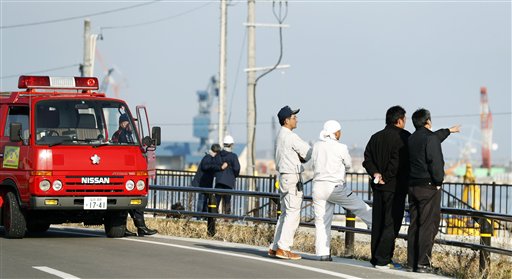 Bomberos y otros miran al puerto para comprobar el nivel del agua, tras la emisión de una alerta de tsunami tras un terremoto en Soma, en la prefectura de Fukushima, Japón, el martes 22 de noviembre de 2016. (Hironori Asakawa/Kyodo News via AP)