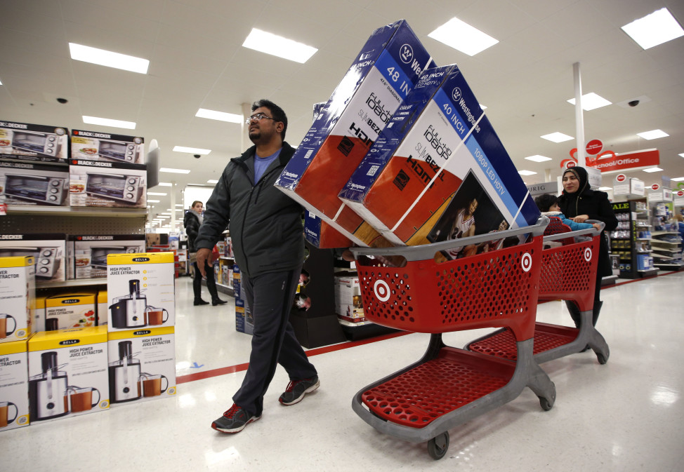 Ahmad Ali and his wife, Ghalzal, of Portland, Maine, look to get in line to pay for three flat-screen televisions while shopping at a Target store just after midnight on Black Friday, Nov. 28, 2014, in South Portland, Maine. (AP Photo/Robert F. Bukaty)