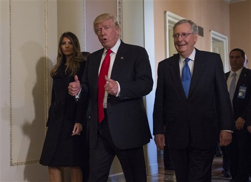 El presidente electo de Estados Unidos, Donald Trump, flanqueado por su esposa Melania y el líder de la mayoría en el Senado, Mitch McConnell, hace un gesto con los pulgares en alto mientras camina por el Capitolio, en Washington, el 10 de noviembre de 2016, tras una reunión. (AP Foto/Molly Riley)
