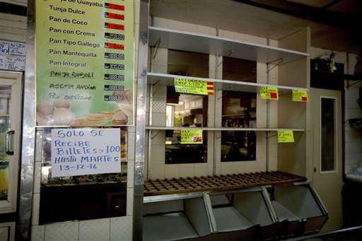 Un letrero en una panadería en el centro de Caracas advierte el lunes 12 de diciembre de 2016 a los compradores que dejará de recibir billetes de 100 bolívares hasta el martes. (AP Foto/Fernando Llano)
