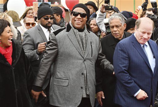 La leyenda de Motown Stevie Wonder camina sobre Milwaukee Avenue, en la que será renombrada una porción en su honor como Stevie Wonder Avenue, junto con la presidenta del ayuntamiento de Detroit Brenda Jones, izquierda, y el alcalde de Detroit Mike Duggan, derecha, durante una ceremonia en Detroit el miércoles 21 de diciembre de 2016. (The Detroit News/ Daniel Mears/Detroit News via AP)