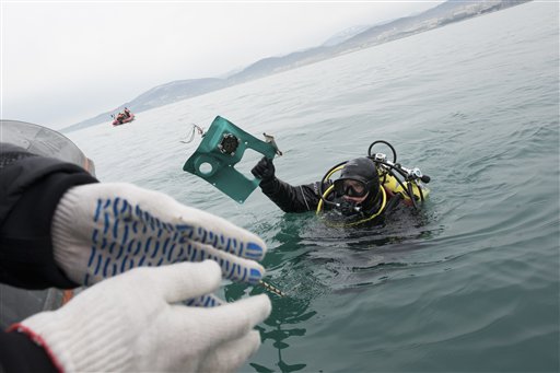 Un buzo del Ministerio de Emergencias de Rusia saca del mar un fragmento de un avión estrellado en el Mar Negro, en las afueras de Sochi, Rusia, el 27 de diciembre de 2016. (AP Foto/Viktor Klyushin)