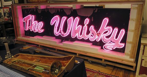 Esta foto del viernes 20 de enero del 2017 muestra la marquesina del legendario club de rock Whisky a Go Go, de Los Angeles, brillando en la casa de subastas Saco River Auction Co., en Biddeford, Maine. El letrero de neón adornó el club de West Hollywood durante el apogeo del punk, new wave y grunge en las década de 1980 y 1990. Será subastado el miércoles 25 de enero. (AP Foto/David Sharp)