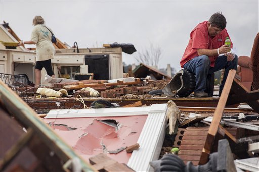 Jeff Bullard contempla los restos de su casa destruida por un tornado mientras su hija Jenny Bullard remueve los escombros, 22 de enero de 2017. (AP Foto/Branden Camp)