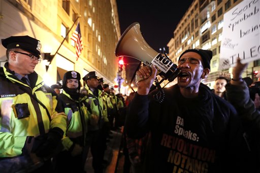 Manifestantes forman frente a una barrera policial ante el Edificio Nacional de la Prensa en Washington en la víspera de la investidura de Donald Trump, 19 de enero de 2017. (AP Photo/John Minchillo)