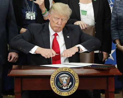 El presidente Donald Trump al momento de firmar una serie de órdenes ejecutivas relacionadas con inmigración, en Washington el miércoles 25 de enero del 2017. (AP Photo/Pablo Martinez Monsivais)