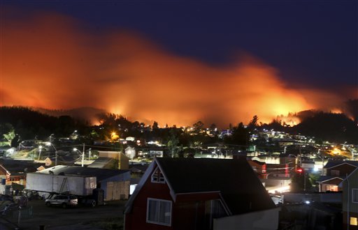 Un incendio se acerca a la comunidad Dichato, Chile, el lunes 30 de enero de 2017. Los bomberos tratan de mantener alejado el fuego de unas 800 casas en la zona. Los incendios han consumido una enorme franja en el sur de Chile desde hace días. (AP Foto/Esteban Felix)