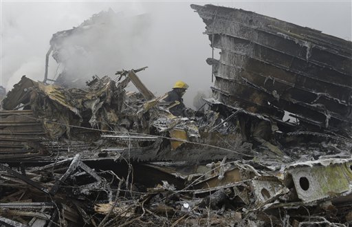 Bomberos trabajan entre los restos de un Boeing 747 de mercancías turco se que estrelló en una zona residencial en las afueras de Bishkek, la capital de Kirguistán, el 16 de enerp de 2017. (AP Foto/Vladimir Voronin)