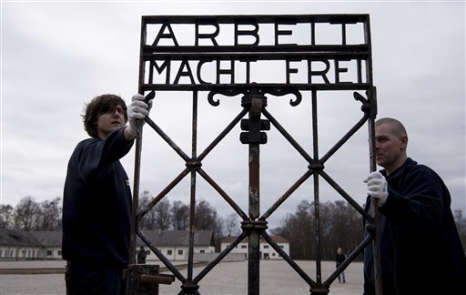 Empleados de una compañía de transporte llevan la reja con la inscripción "Arbeit macht frei" (El trabajo te libera) en el memorial del campo de concentración nazi en Dachau, Alemania, el miércoles, 22 de febrero del 2017. La puerta fue robada en el 2014 y reapareció en noviembre del 2016 cerca de Bergen Noruega. (Sven Hoppe/dpa via AP)