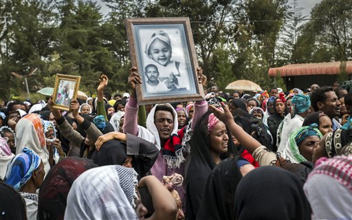 Familiares lloran la muerte de sus seres queridos mientras sostienen imágenes de los fallecidos por una avalancha en un vertedero de basuras antes de un servicio religioso en la iglesia de Gebrekristos, en Adís Abeba, Etiopía, el 13 de marzo de 2017. (AP Foto/Mulugeta Ayene)