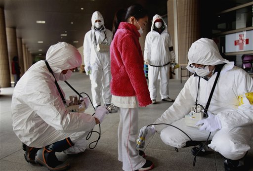 ARCHIVO - En esta imagen de archivo del 24 de marzo de 2011, un joven evacuado pasa un control de radiación en un refugio tras un tsunami que golpeó la central nuclear de Fukushima Dai-ichi en Fukushima, en el nordeste de Tokio. (AP Foto/Wally Santana, Archivo)